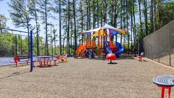 our playground is equipped with a swing set and picnic tables at 300 Riverside Apartments, Austell, GA